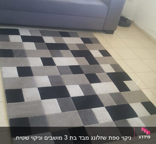 שטיח מרובע בצבעים שחור ואפור על רצפה ליד ספה אפורה